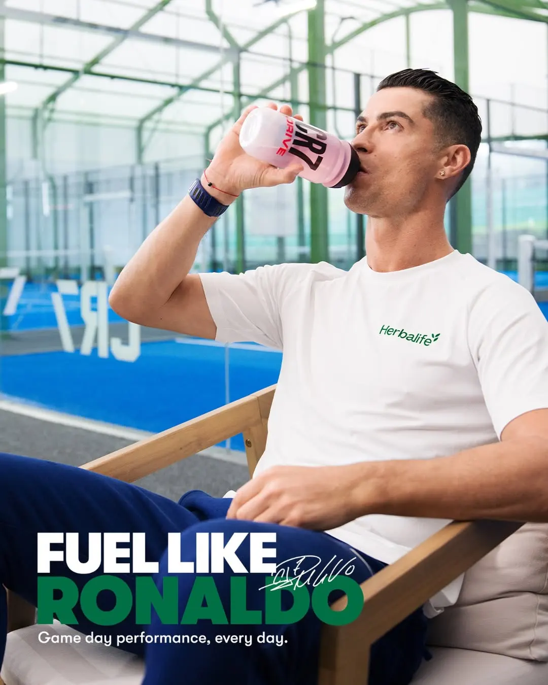 Herbalife H24 CR7 Drive Hipotonik Sporcu İçeceği Cristiano Ronaldo Serisi Herbalife tişörtü giymiş Cristiano Ronaldo CR7 Drive matarasından kırmızı hipotonik sporcu içeceği içerken